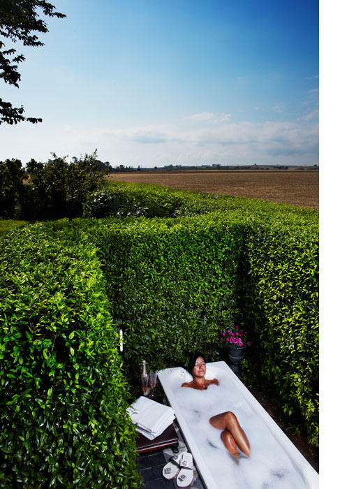 A woman is lying in a bathtub outdoors