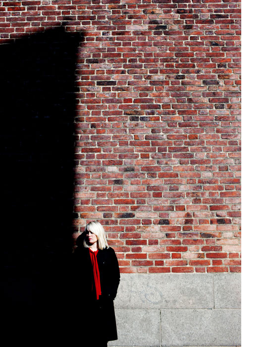 A picture of Ann Heberlein against a brick wall