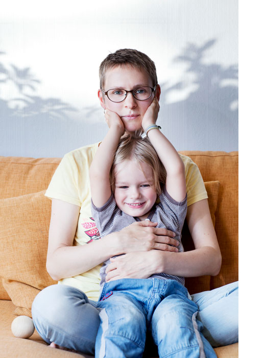 A woman and a little girl sitting in a sofa