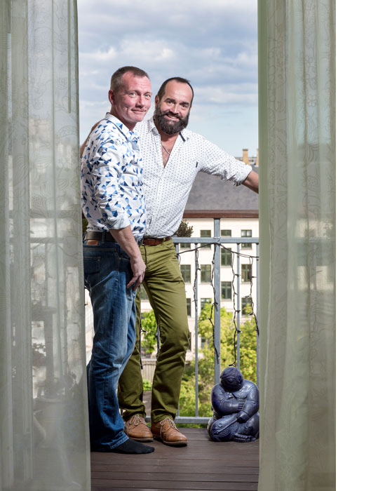 Two happy men standing on a balcony